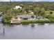 Charming waterfront home boasts a tiki hut, dock, and pool, set amidst lush landscaping and serene waters at 1410 San Jose Dr, Englewood, FL 34223