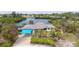 Waterfront home with a carport, pool, tiki hut, dock, and tropical landscaping at 1410 San Jose Dr, Englewood, FL 34223