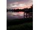 Serene waterfront view features tranquil waters, a wooden dock, and lush greenery, offering a peaceful retreat at 1410 San Jose Dr, Englewood, FL 34223