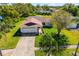 An elevated view of a home accented by palm trees, showing off a green yard and solar panels on the roof at 1525 Fleetwood Dr, Sarasota, FL 34232