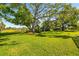Lush green backyard with mature trees and access to a scenic pond view at 1525 Fleetwood Dr, Sarasota, FL 34232