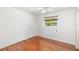 Bright bedroom features hardwood floors, ceiling fan and window with tree view at 1525 Fleetwood Dr, Sarasota, FL 34232