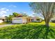 Pleasant home with a manicured lawn, a neatly trimmed shrub, and a vivid red front door at 1525 Fleetwood Dr, Sarasota, FL 34232
