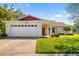 Charming single-story home with a two-car garage, red front door, and well-kept lawn and landscaping at 1525 Fleetwood Dr, Sarasota, FL 34232