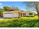 Attractive home showcasing a well-maintained lawn, nicely landscaped shrubbery, and a bright red front door at 1525 Fleetwood Dr, Sarasota, FL 34232