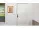 Clean, well-lit hallway with a white door, neutral wall color, and a decorative picture for added style at 1525 Fleetwood Dr, Sarasota, FL 34232