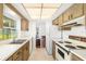 Efficient kitchen layout with classic cabinets, tile floors, and easy access to other living spaces at 1525 Fleetwood Dr, Sarasota, FL 34232