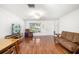 Bright living room featuring laminate floors, a ceiling fan, and a large window bringing in natural light at 1525 Fleetwood Dr, Sarasota, FL 34232