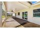 The covered patio space with a ceiling fan, table, and windows offers relaxation and entertainment at 1525 Fleetwood Dr, Sarasota, FL 34232