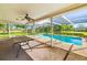 Screened-in pool area with ceiling fan and table, perfect for outdoor dining and relaxation at 1525 Fleetwood Dr, Sarasota, FL 34232