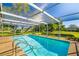 Sparkling pool is surrounded by a screen enclosure and lush landscaping, creating a private oasis at 1525 Fleetwood Dr, Sarasota, FL 34232