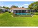Beautiful screened pool surrounded by lush landscaping and well-maintained green lawn, perfect for outdoor enjoyment at 1525 Fleetwood Dr, Sarasota, FL 34232