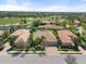 Aerial view of beautiful homes amidst lush landscaping, featuring red tile roofs and picturesque neighborhood streets at 15508 Leven Links Pl, Lakewood Ranch, FL 34202