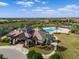 Aerial view of a clubhouse with a resort-style pool, lush landscaping, and surrounding neighborhood at 15508 Leven Links Pl, Lakewood Ranch, FL 34202