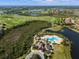 Aerial view of a community featuring a golf course, resort-style pool, clubhouse, and surrounding neighborhood at 15508 Leven Links Pl, Lakewood Ranch, FL 34202