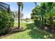 Backyard view showcases lush greenery, mature trees, a tranquil pond, and a well-maintained lawn at 15508 Leven Links Pl, Lakewood Ranch, FL 34202