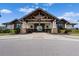 Inviting clubhouse entrance with stone accents, timber beams, and lush landscaping offering a warm welcome at 15508 Leven Links Pl, Lakewood Ranch, FL 34202