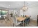 Open-concept dining area featuring a rustic wood table, contemporary chandelier, and seamless access to living spaces at 15508 Leven Links Pl, Lakewood Ranch, FL 34202