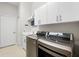 This laundry room has modern machines and white shelving for storage at 15508 Leven Links Pl, Lakewood Ranch, FL 34202