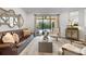 Comfortable living room with a leather sofa, accent chairs, and a sliding door leading to the outdoor area at 15508 Leven Links Pl, Lakewood Ranch, FL 34202