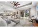 Bright living room with large sectional sofa, ceiling fan and glass doors to outdoor patio at 15508 Leven Links Pl, Lakewood Ranch, FL 34202