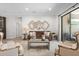 Bright living room featuring a leather sofa, neutral color scheme, and sliding glass doors at 15508 Leven Links Pl, Lakewood Ranch, FL 34202