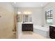 This main bathroom includes a standalone shower and tub, as well as a dark vanity at 15508 Leven Links Pl, Lakewood Ranch, FL 34202