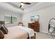 This main bedroom includes a ceiling fan, television, and a window providing natural light at 15508 Leven Links Pl, Lakewood Ranch, FL 34202
