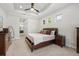 This main bedroom includes a tray ceiling, a ceiling fan, and small windows letting in natural light at 15508 Leven Links Pl, Lakewood Ranch, FL 34202