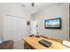 Functional home office with modern desk, TV, closet and natural light at 15508 Leven Links Pl, Lakewood Ranch, FL 34202