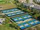 Aerial view of multiple pickleball courts with players and surrounding landscaping in a residential community at 15508 Leven Links Pl, Lakewood Ranch, FL 34202