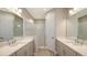 Elegant bathroom featuring dual sinks, quartz counters, and a glass walk-in shower at 18137 Franklin Park Ct, Venice, FL 34293
