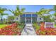 Club Wysteria with vibrant landscaping, including colorful flowers and palm trees at 18137 Franklin Park Ct, Venice, FL 34293