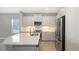 Modern kitchen boasts stainless appliances, white cabinetry and quartz countertops with tile backsplash at 18137 Franklin Park Ct, Venice, FL 34293