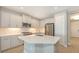 The large kitchen features stainless appliances, white cabinets, a quartz island, and tile floors at 18137 Franklin Park Ct, Venice, FL 34293