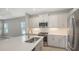 Modern kitchen features stainless steel appliances, granite countertops, light gray cabinets and a kitchen island at 18137 Franklin Park Ct, Venice, FL 34293