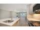 Bright kitchen features an island with stainless steel sink, tiled backsplash, and open view of the living area at 18137 Franklin Park Ct, Venice, FL 34293