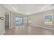 Bright living room with tray ceiling, tile floors, and sliding glass doors to lanai at 18137 Franklin Park Ct, Venice, FL 34293