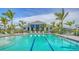 Beautiful community pool and clubhouse surrounded by palm trees at 18137 Franklin Park Ct, Venice, FL 34293