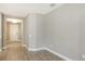 An empty room with neutral colored walls and tile flooring; features a view into the hallway at 18137 Franklin Park Ct, Venice, FL 34293