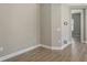 An empty room with neutral colored walls and tile flooring; features a view into another room at 18137 Franklin Park Ct, Venice, FL 34293