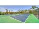 Outdoor pickleball courts featuring green and blue surfaces, surrounded by fences, landscaping and palm trees at 18297 Vizcaya Ct, Venice, FL 34293