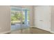An empty room with sliding doors leading to an outdoor patio and a green landscape at 18297 Vizcaya Ct, Venice, FL 34293