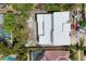 Aerial view of a modern home featuring a flat white roof amidst other homes with private pools at 1879 Hibiscus St, Sarasota, FL 34239