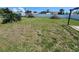 Spacious back yard featuring green grass, a white fence, and leafy trees offers lots of space for outdoor fun at 22201 Olean Blvd, Port Charlotte, FL 33952