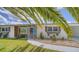 Charming single-story home with well-maintained lawn, blue front door, and lovely landscaping at 22201 Olean Blvd, Port Charlotte, FL 33952