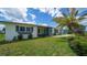 Charming single-story home with blue front door, well-maintained lawn, and mature landscaping at 22201 Olean Blvd, Port Charlotte, FL 33952