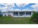 Enclosed sunroom off the back of the house with tiled patio and expansive lawn at 22201 Olean Blvd, Port Charlotte, FL 33952