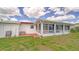 Enclosed sunroom off the back of the house with tiled patio and expansive lawn at 22201 Olean Blvd, Port Charlotte, FL 33952