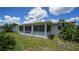 Enclosed sunroom on house rear leads to the grassy yard at 22201 Olean Blvd, Port Charlotte, FL 33952